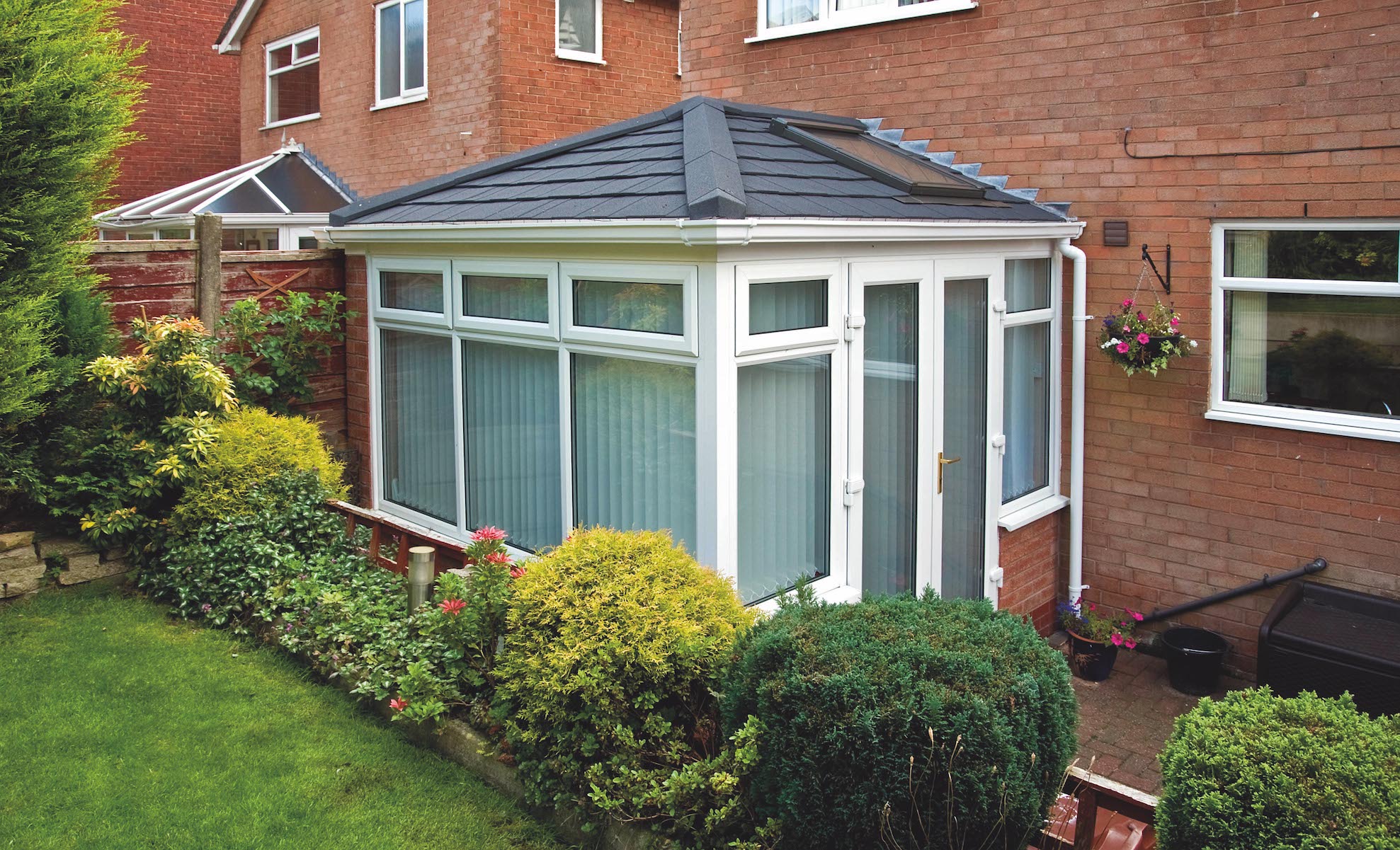 Conservatory refurbished with a Metrotile Lightweight Roof System Shingle Charcoal and Velux Window